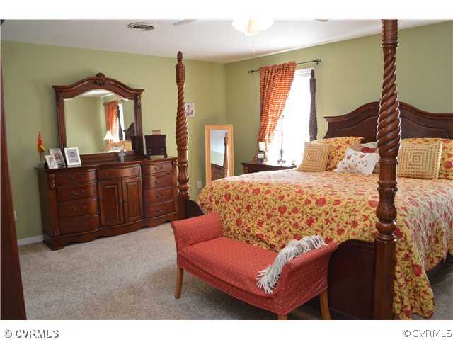 4706 Twin Cedars Road Chester, VA 23831 - Photo 17 of 24 a bedroom with a bed and dresser with mirror