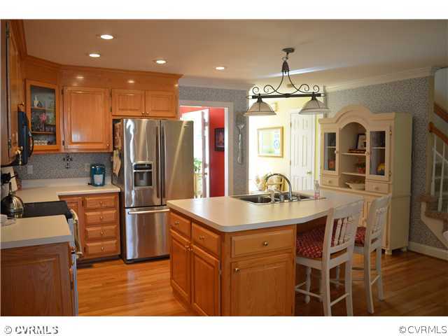 4706 Twin Cedars Road Chester, VA 23831 - Photo 4 of 24 a kitchen with stainless steel appliances kitchen island granite countertop a refrigerator and a sink