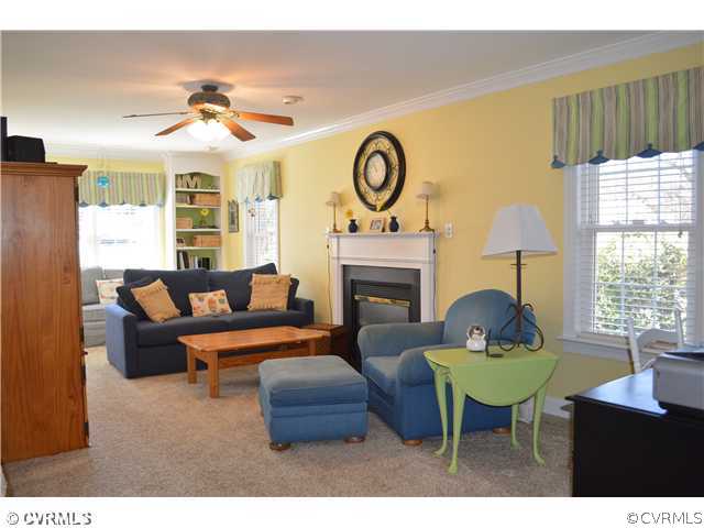 4706 Twin Cedars Road Chester, VA 23831 - Photo 7 of 24 a living room with furniture a fireplace and a large window