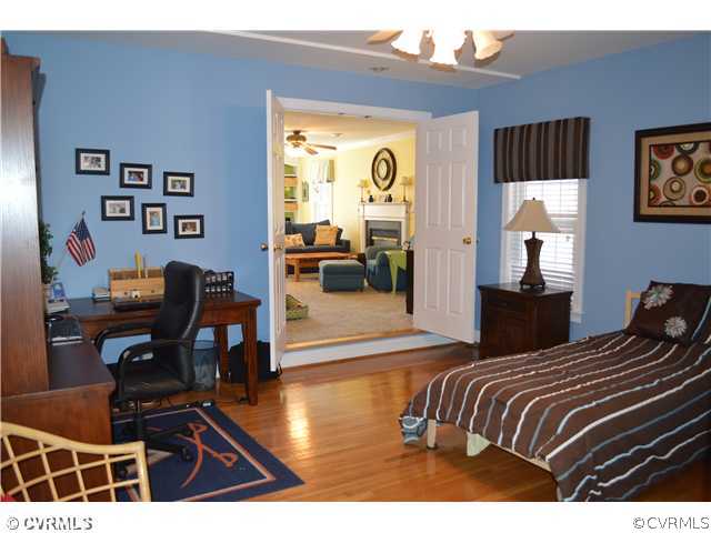 4706 Twin Cedars Road Chester, VA 23831 - Photo 10 of 24 a bedroom with a bed and wooden floor