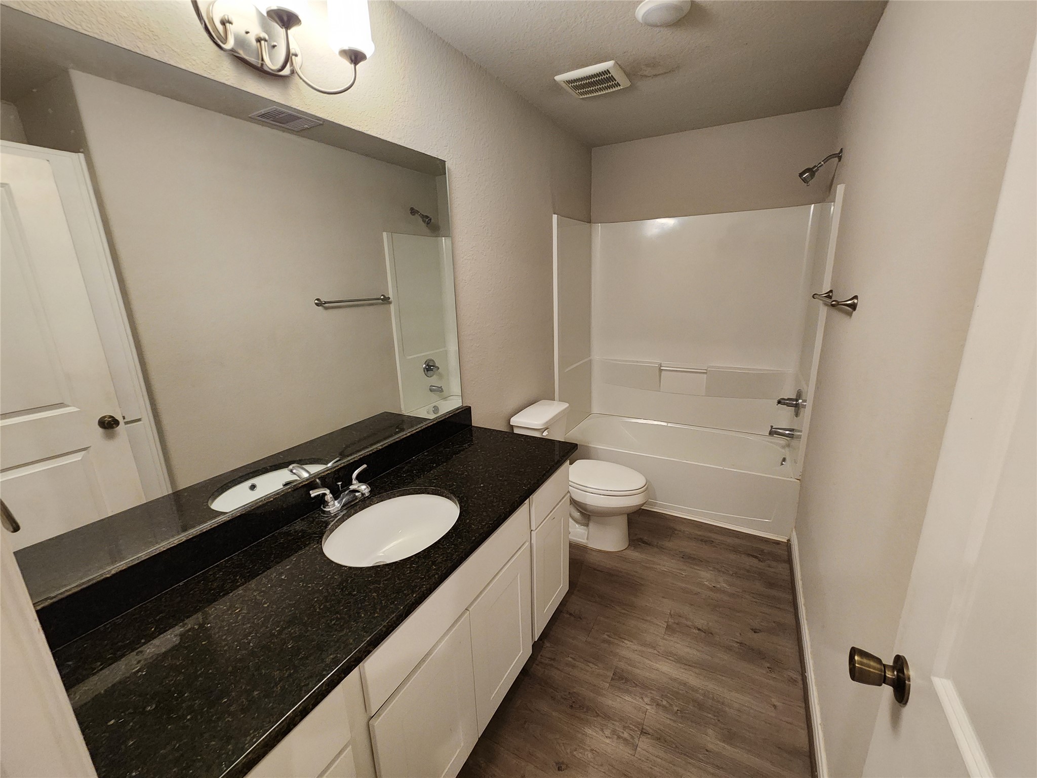 422 3rd Street Rosenberg, TX 77471 - Photo 11 of 14 a bathroom with a granite countertop sink a toilet a mirror and shower