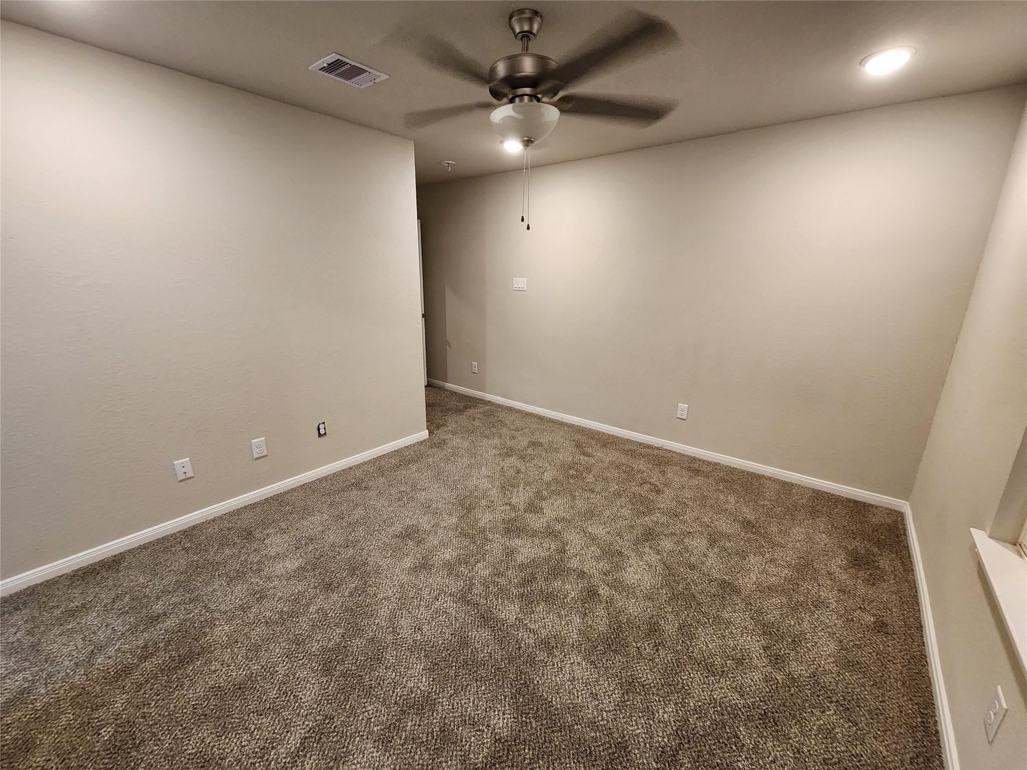 422 3rd Street Rosenberg, TX 77471 - Photo 5 of 14 an empty room with a ceiling fan and a fan