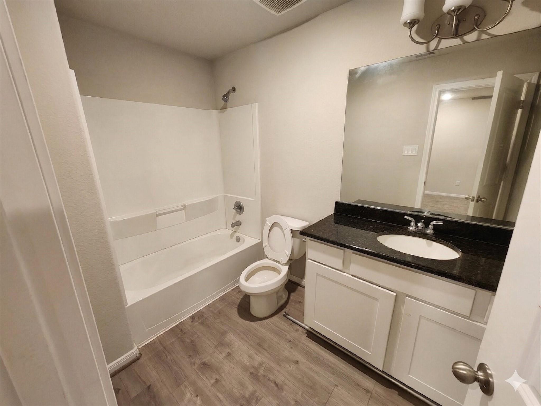 422 3rd Street Rosenberg, TX 77471 - Photo 10 of 14 a bathroom with a granite countertop sink toilet a mirror and shower