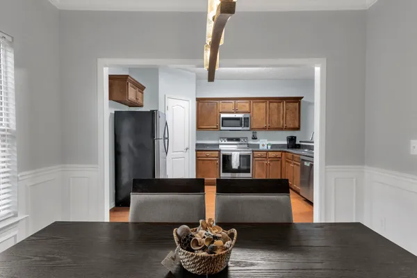a kitchen with stainless steel appliances granite countertop a refrigerator a stove and a wooden floors