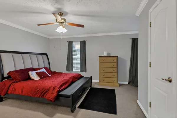 a bedroom with a bed and a ceiling fan