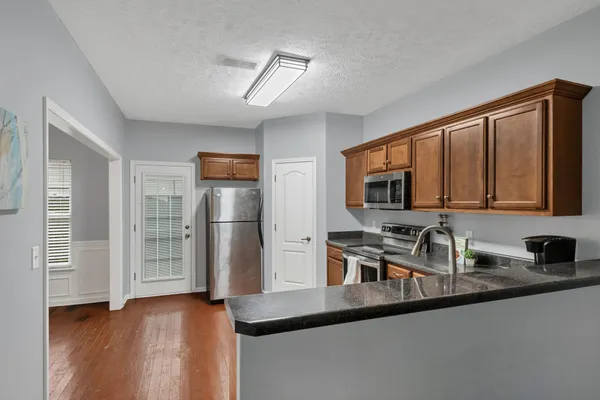 a kitchen with stainless steel appliances granite countertop a sink stove and refrigerator