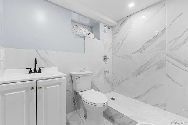 a white toilet sitting next to a bathroom sink