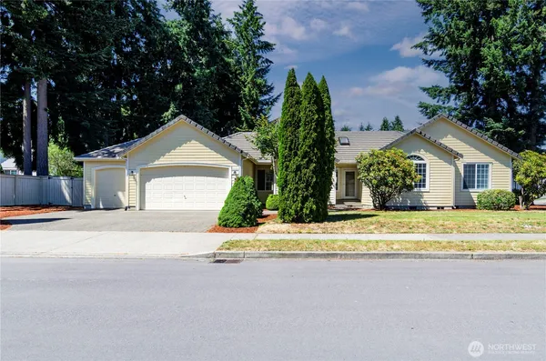 a view of a house with a street and trees