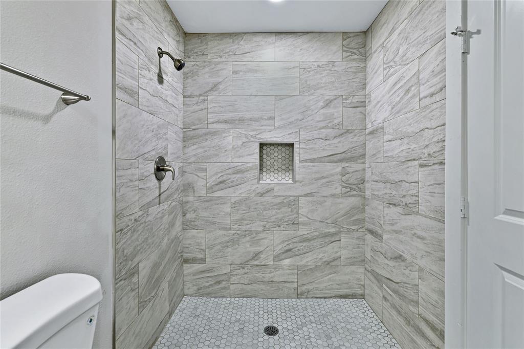 907 Southwest Main Street Ennis, TX 75119 - Photo 18 of 28 a bathroom with a shower