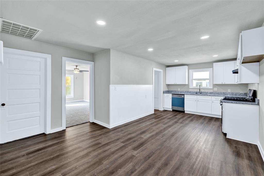 907 Southwest Main Street Ennis, TX 75119 - Photo 3 of 28 a view of a kitchen with wooden floor and electronic appliances