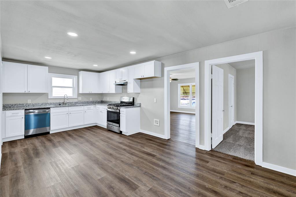 907 Southwest Main Street Ennis, TX 75119 - Photo 4 of 28 a kitchen with wooden floors and appliances