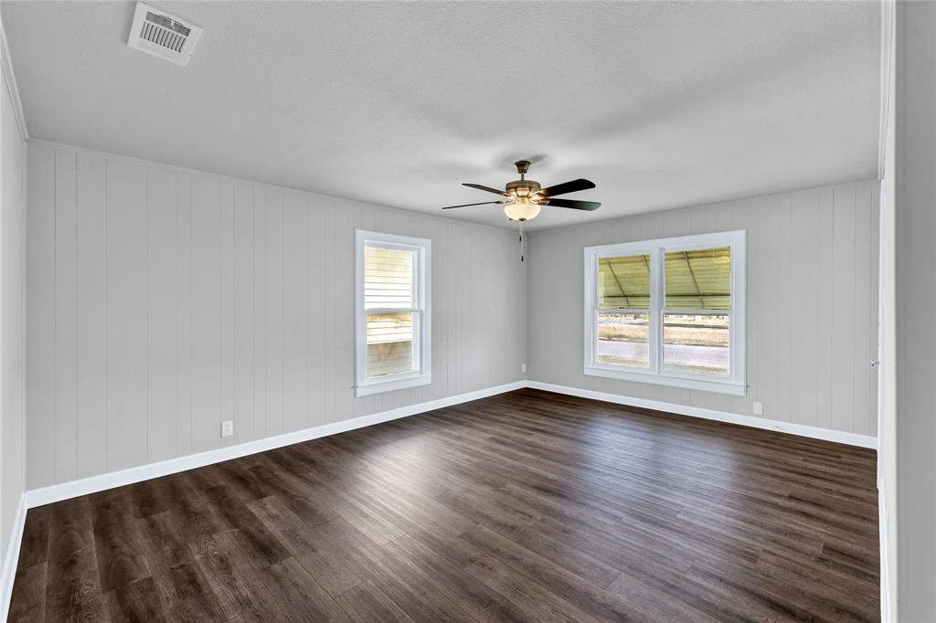 907 Southwest Main Street Ennis, TX 75119 - Photo 7 of 28 a view of an empty room with wooden floor and a window