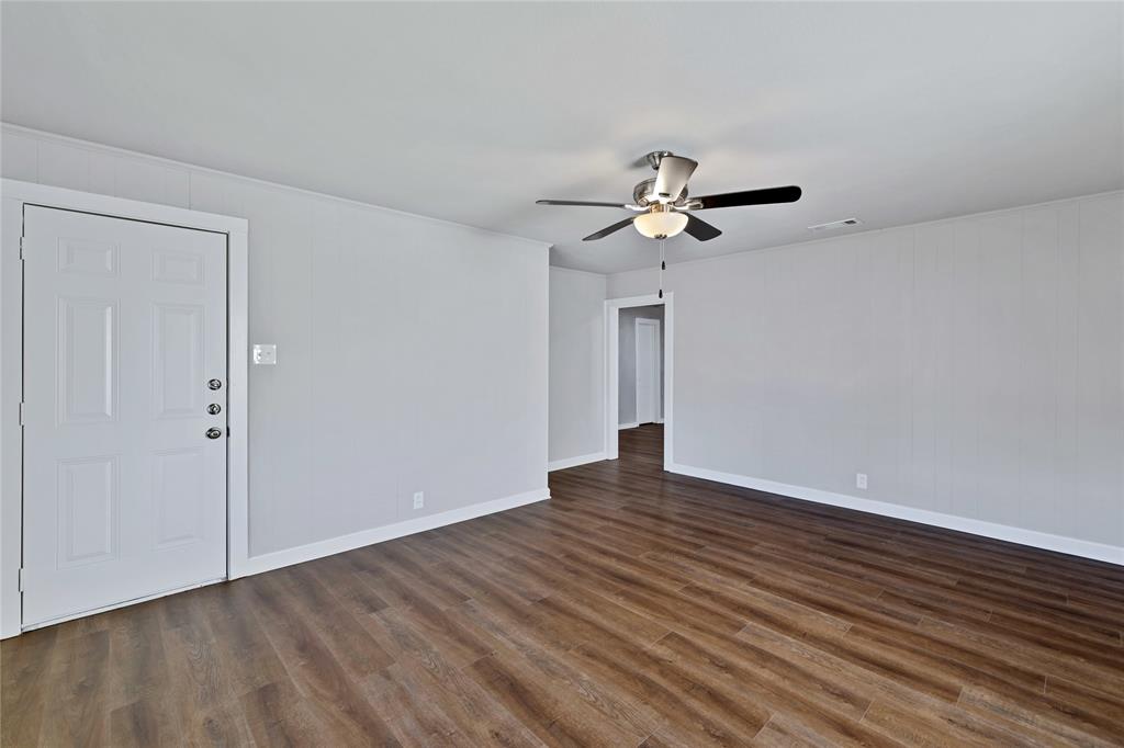 907 Southwest Main Street Ennis, TX 75119 - Photo 8 of 28 wooden floor in an empty room with a window