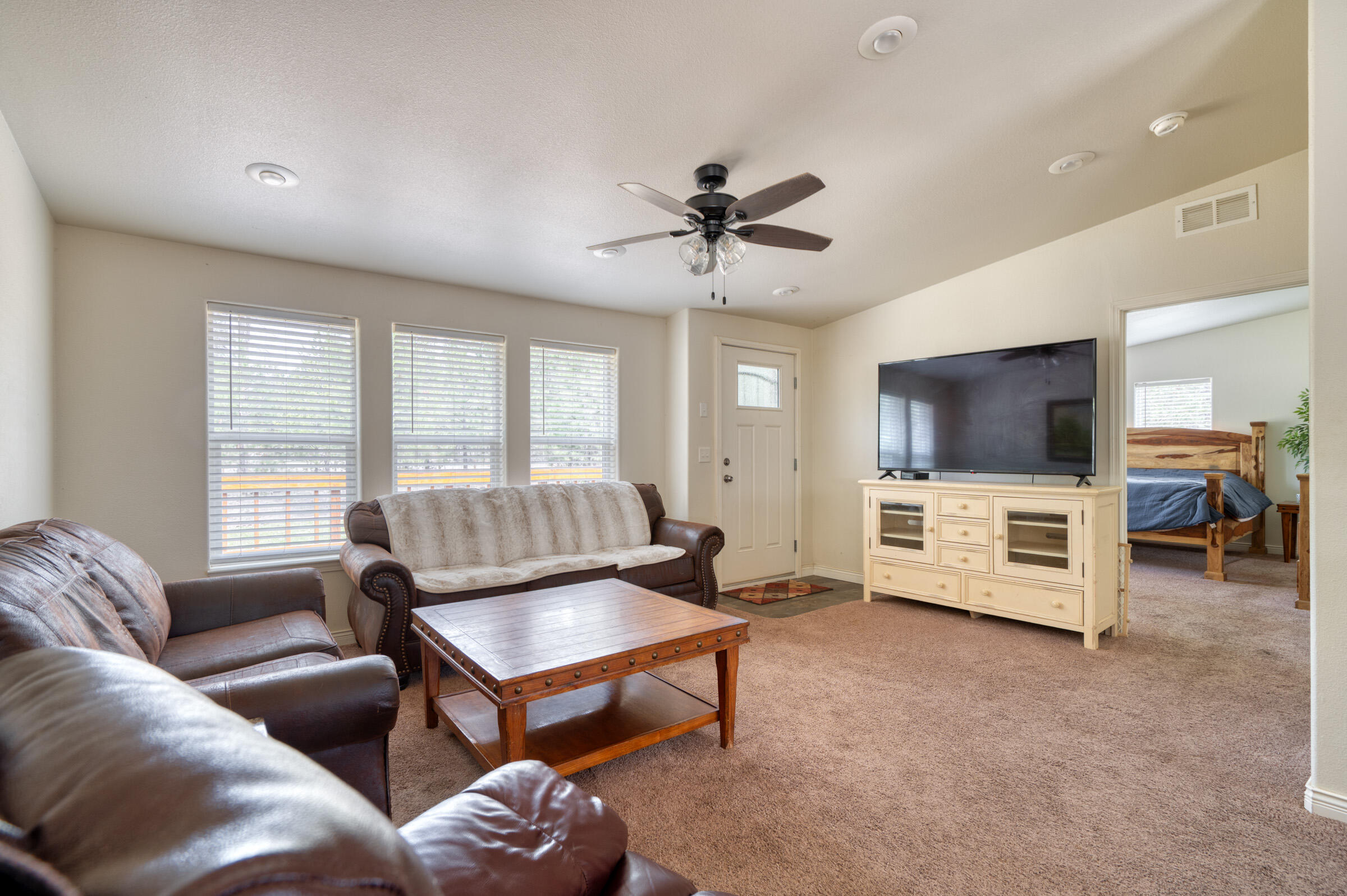 52648 Ammon Road La Pine, OR 97739 - Photo 16 of 44 a living room with furniture a ceiling fan and a flat screen tv