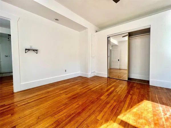 a view of empty room with wooden floor
