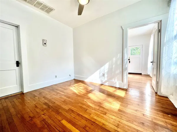 a view of a room with wooden floor and white walls