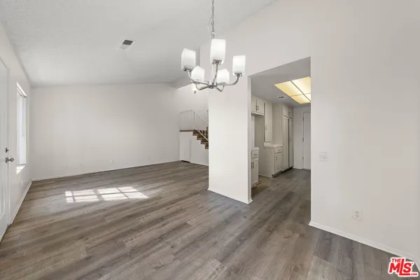 a view of a room with wooden floor and a ceiling fan
