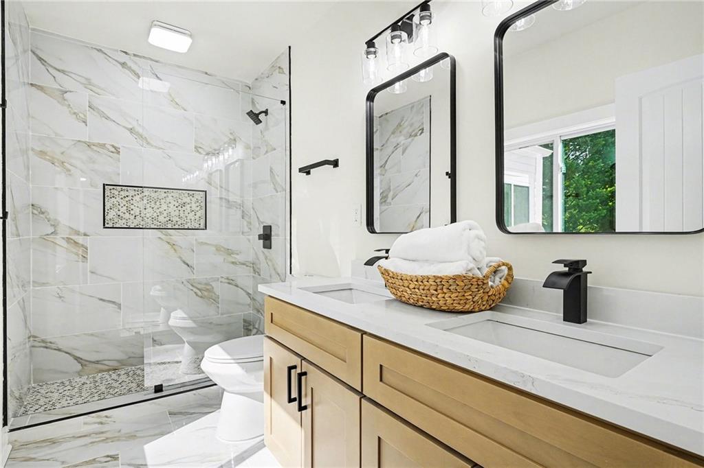 1275 Westridge Road Southwest Atlanta, GA 30311 - Photo 15 of 34 a bathroom with a granite countertop sink mirror vanity and toilet