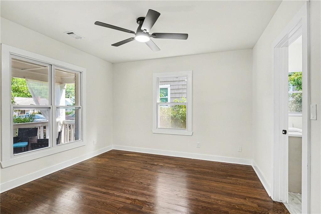 1275 Westridge Road Southwest Atlanta, GA 30311 - Photo 19 of 34 a view of an empty room with wooden floor and a window
