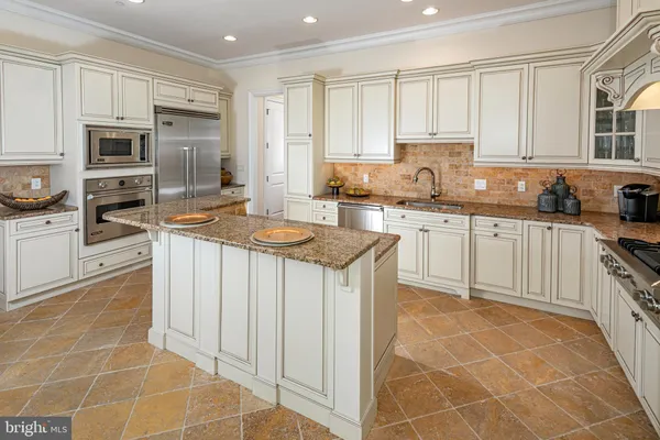 a kitchen with stainless steel appliances granite countertop a stove sink and cabinets