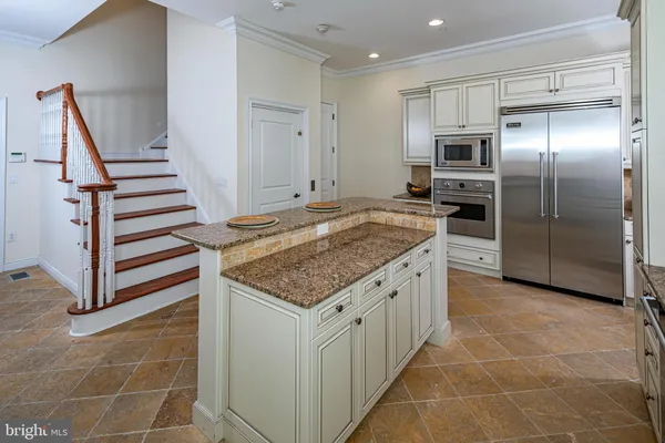 a kitchen with kitchen island granite countertop a sink stove and refrigerator