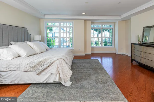 a spacious bedroom with a bed and wooden floor
