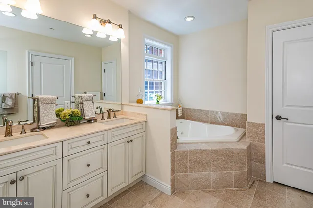 a spacious bathroom with a double vanity sink bathtub and next to a window