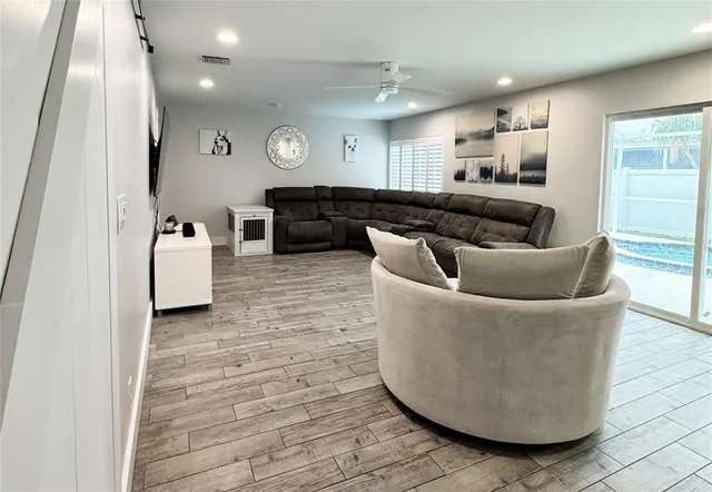 a living room with furniture and a view of kitchen