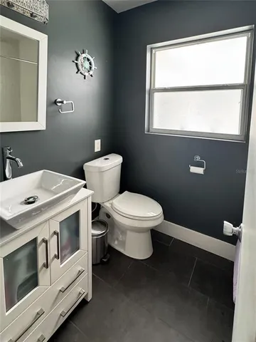 a bathroom with a sink a toilet and a mirror