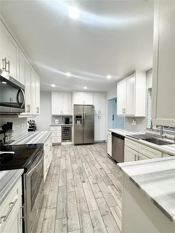 a kitchen with stainless steel appliances kitchen island granite countertop a refrigerator sink and cabinets