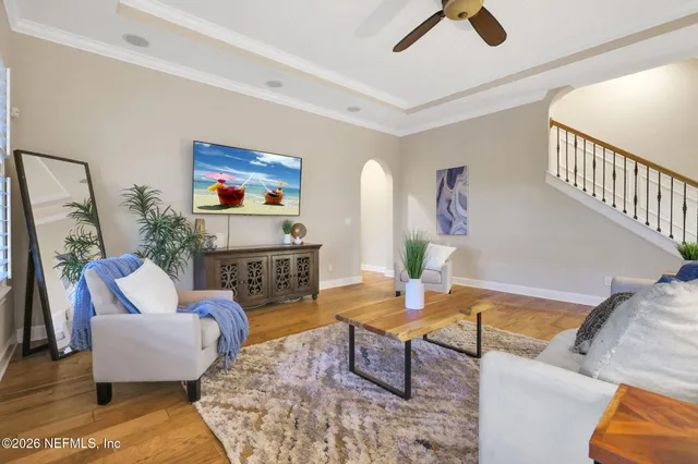 a living room with furniture kitchen view and a large window