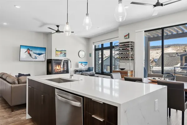 a large kitchen with kitchen island a large counter space a sink appliances and a large window