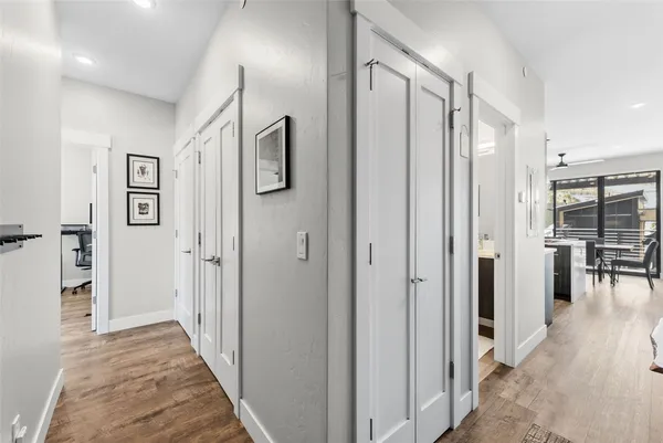 a view of a hallway with wooden floor and dining room