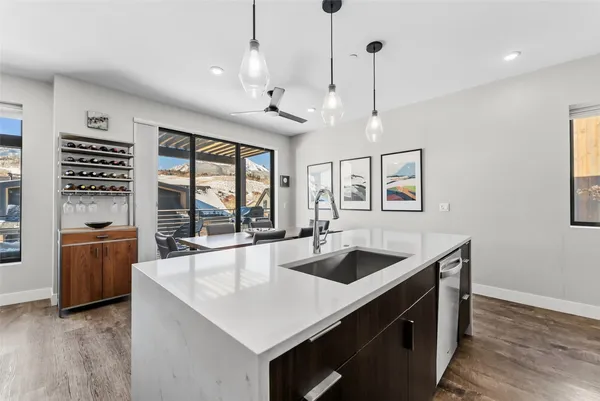 a kitchen with stainless steel appliances granite countertop a sink a stove and a wooden floors