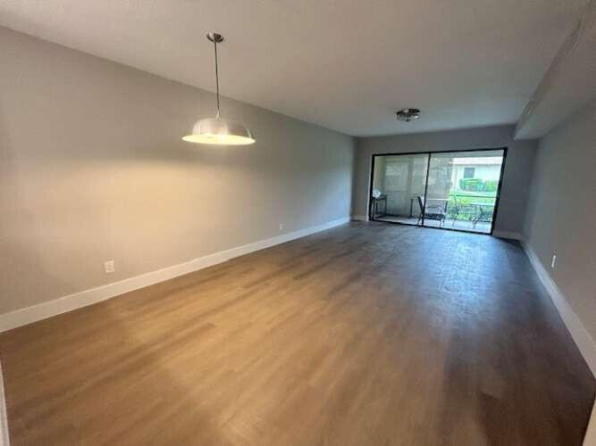 1101 Pinecrest Circle, Unit F Jupiter, FL 33458 - Photo 12 of 18 an empty room with wooden floor and windows