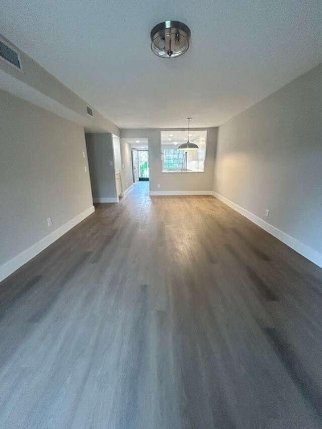 1101 Pinecrest Circle, Unit F Jupiter, FL 33458 - Photo 13 of 18 an empty room with wooden floor and windows