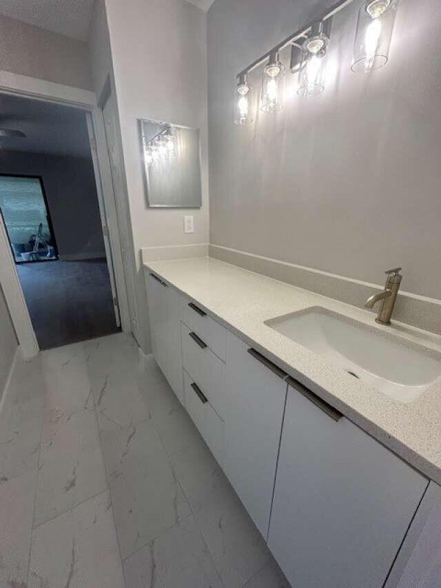 1101 Pinecrest Circle, Unit F Jupiter, FL 33458 - Photo 17 of 18 a bathroom with double vanity sink and mirror