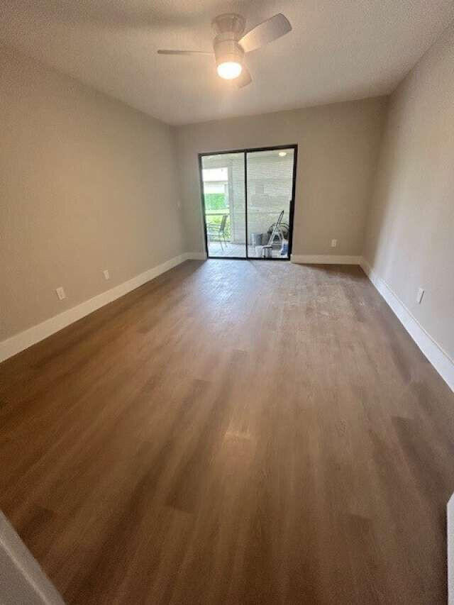 1101 Pinecrest Circle, Unit F Jupiter, FL 33458 - Photo 18 of 18 an empty room with wooden floor and windows