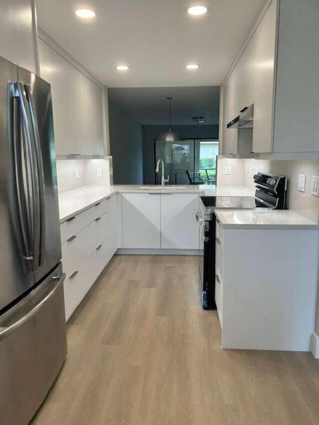 1101 Pinecrest Circle, Unit F Jupiter, FL 33458 - Photo 2 of 18 a kitchen with stainless steel appliances a refrigerator sink and stove