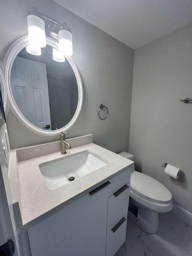 1101 Pinecrest Circle, Unit F Jupiter, FL 33458 - Photo 8 of 18 a bathroom with a toilet sink and mirror