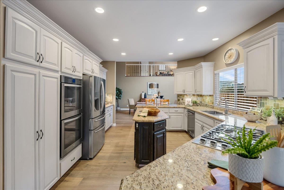 17446 Serene Drive Morgan Hill, CA 95037 - Photo 26 of 82 a kitchen with granite countertop kitchen island stainless steel appliances a stove a sink and a refrigerator