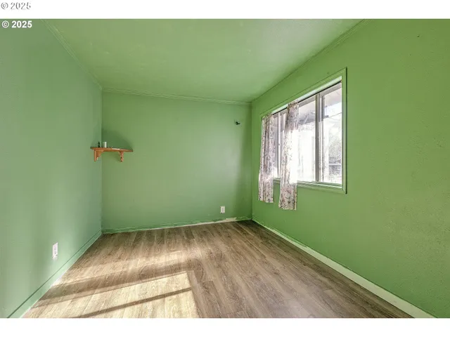 a view of a room that has a window and wooden floor