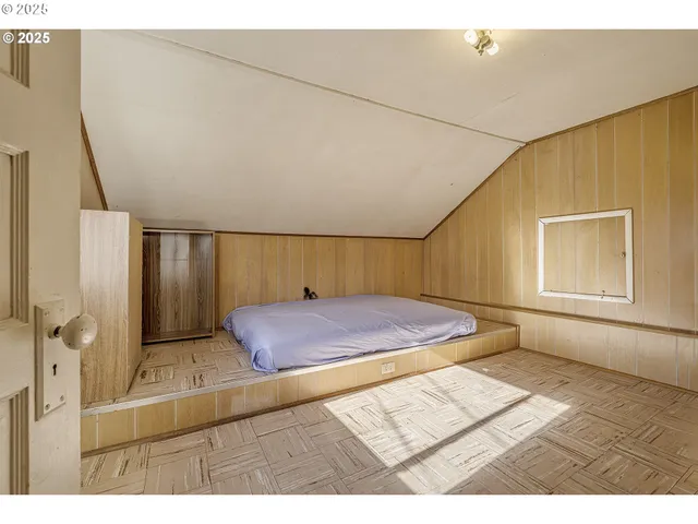 a bedroom with a bed and a painting on the wall