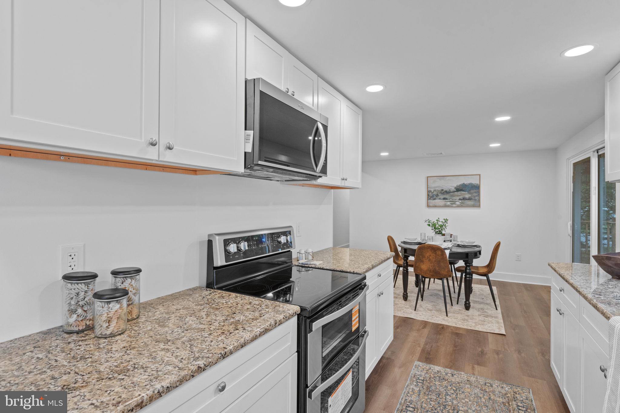 229 Cider Press Road Manheim, PA 17545 - Photo 15 of 47 a kitchen with stainless steel appliances granite countertop a stove top oven a sink a dining table and chairs
