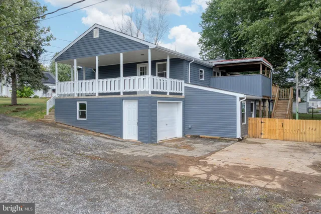 a view of house with a yard and large tree