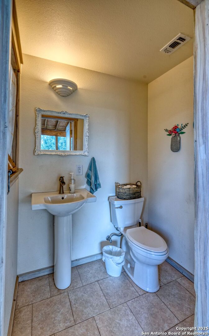 565 Loop Road Uvalde, TX 78801 - Photo 16 of 78 a bathroom with a toilet sink and mirror