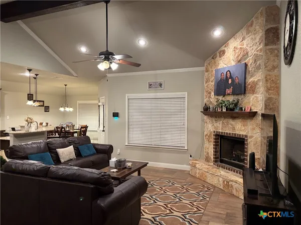 a living room with furniture a fireplace and a chandelier