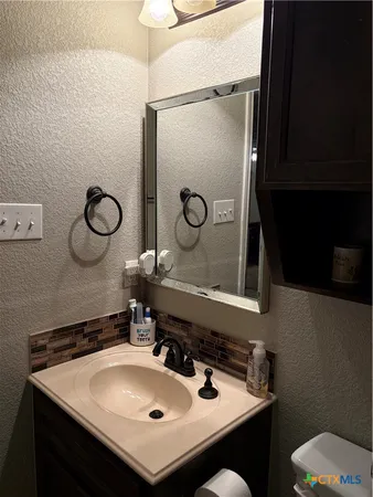a bathroom with a sink mirror and toilet