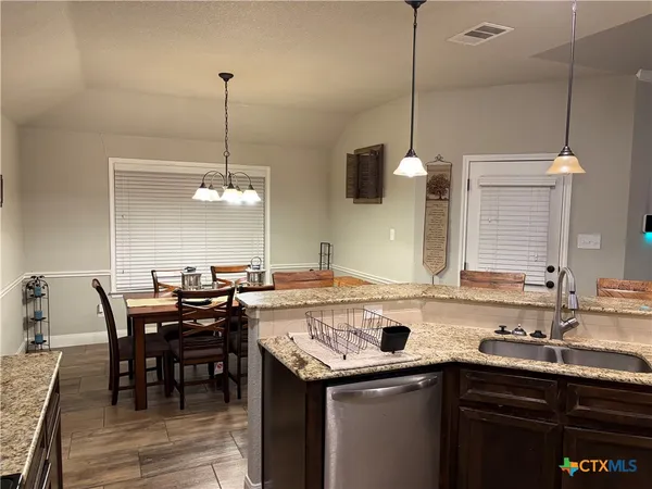 a kitchen with a sink a counter space appliances and cabinets