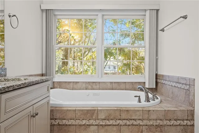 a bathroom with bathtub and window